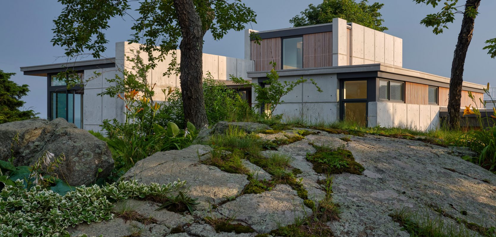 concrete home nestled into landscape with ledge